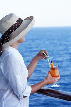 pretty girl with a cocktail on a journey to the sea