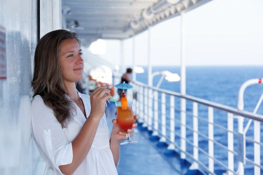 cute girl with a cocktail on a journey to the sea