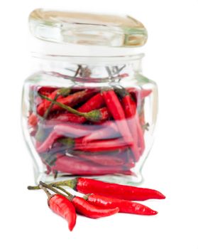 red chili pepper in a glass jar isolated on white background