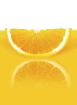 a slice of orange lying in a yellow orange juice