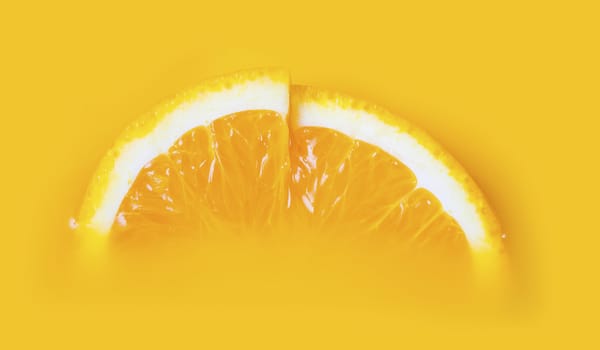 Two fresh a slice of orange on yellow background