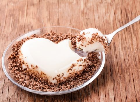 vanilla jelly and chocolate with a spoon on a wooden background