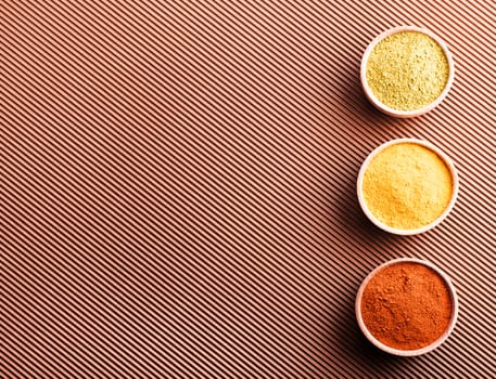 hops-suneli,turmeric,paprika in a wooden bowl on a brown background