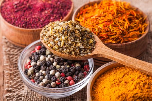 dry spices in a wooden and glass bowls close-up on a vintage background