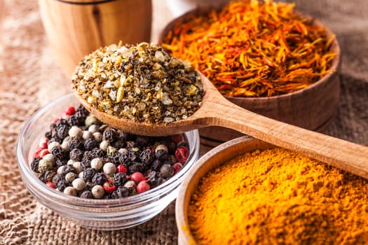 set dry spices in a wooden and glass bowls close-up on a vintage background