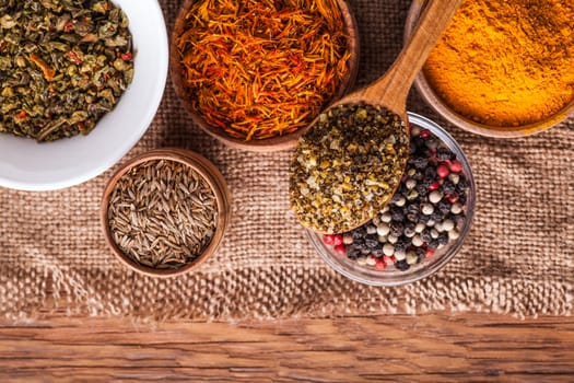 set dry spices in a wooden and glass bowls on a vintage background