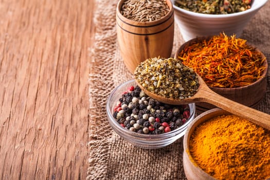 spices in a wooden and glass bowls on a vintage background