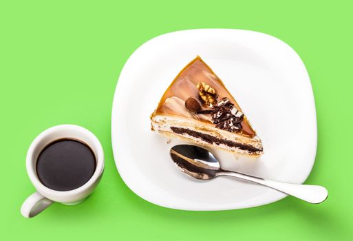 fresh piece of cake and a cup of coffee on a green background