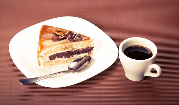 piece of cake and a cup of coffee on a brown background