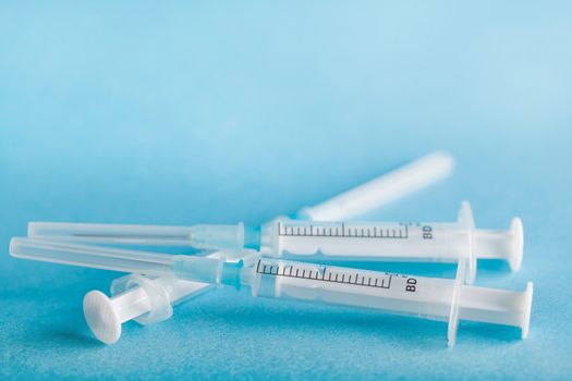 three disposable syringe close-up on a blue background