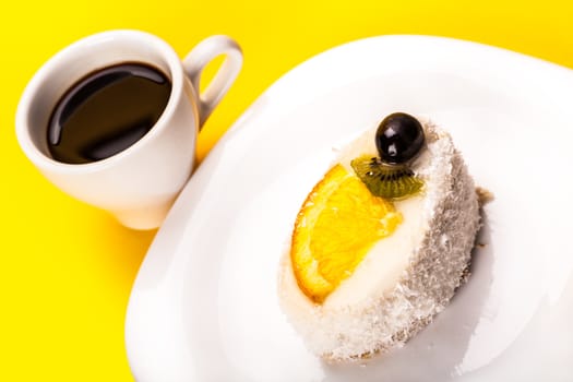 coconut piece of cake and coffee on a yellow background