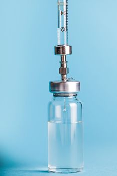 vial medicines and syringe close-up on a blue background