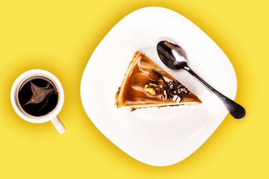 fresh piece of cake and a cup of coffee on a yellow background