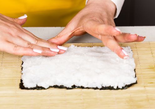 chef places the rice on the nori sheet