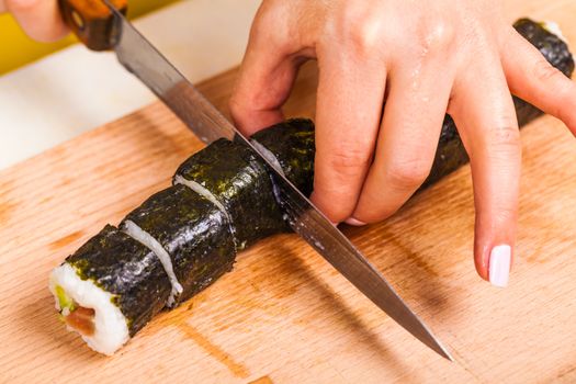 chef cuts the roll on a wooden board