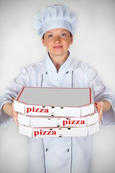 cook with a pizza in box on a light background