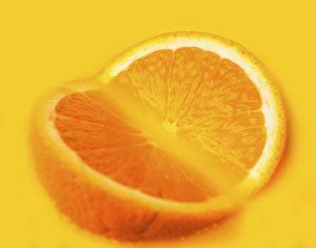 two slices of orange closeup lying in the yellow juice