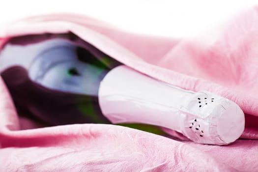 a bottle of sparkling champagne wrapped in pink tissue