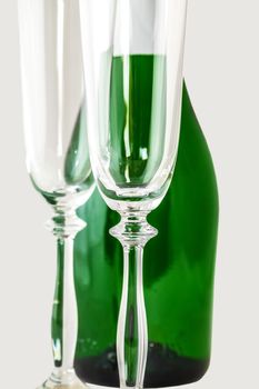 bottle of champagne with two glasses of clean on a light background