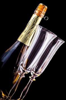 bottle of champagne and two glasses on a dark background