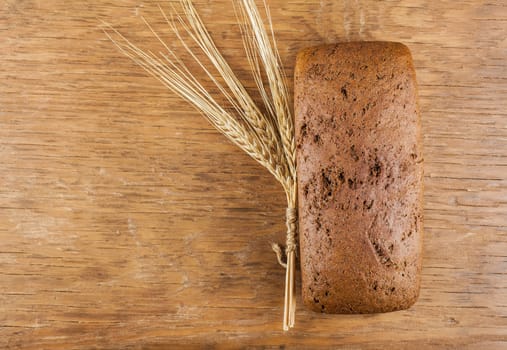 rye bread with ears of wheat on the wooden background