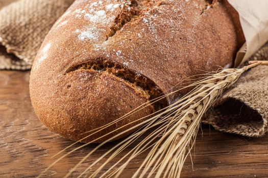 bread and wheat ears close-up on a wooden background