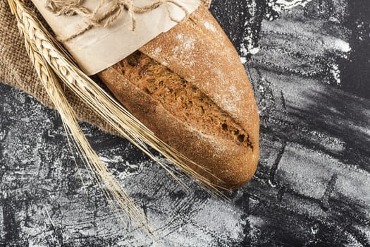 rye bread with ears of wheat on a dark background