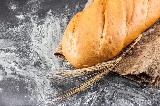 white bread with ears of wheat on a dark background