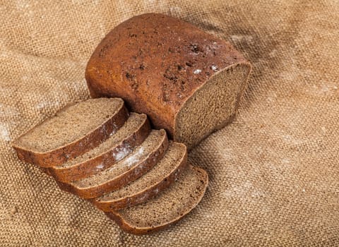 sliced loaf brown bread on old cloth