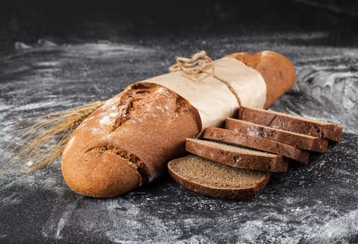 sliced loaf black bread on a dark background