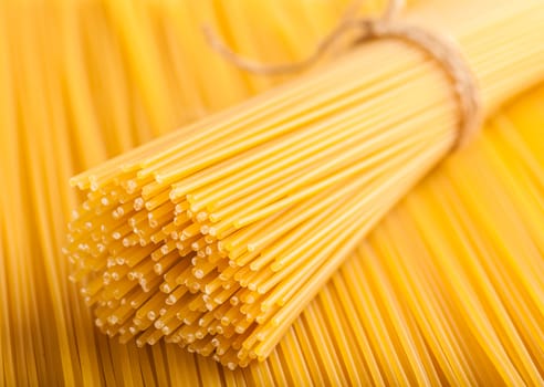 yellow background neatly lined with raw spaghetti