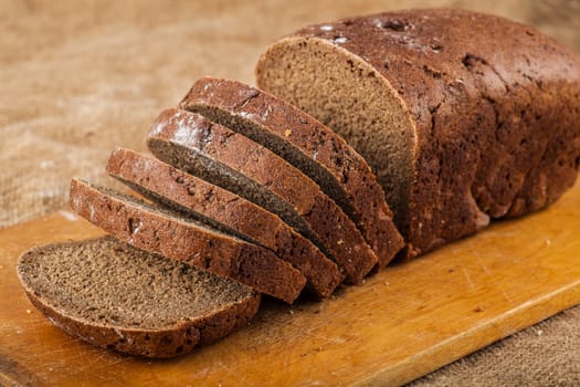 sliced loaf rye bread on a wooden board