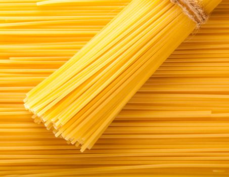 yellow background neatly laid out raw spaghetti
