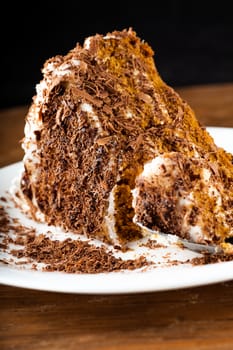 piece of chocolate cake on a plate on a wooden background