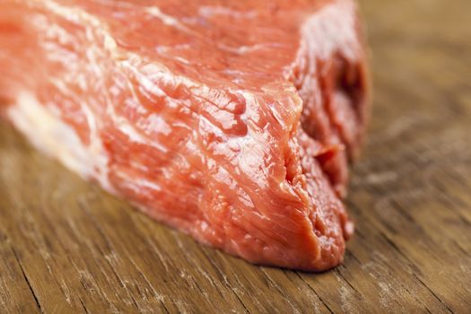 fresh beef tenderloin closeup on wooden background