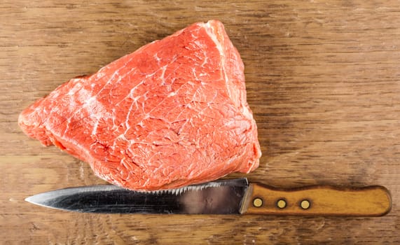 beef fillet with a knife on a wooden background