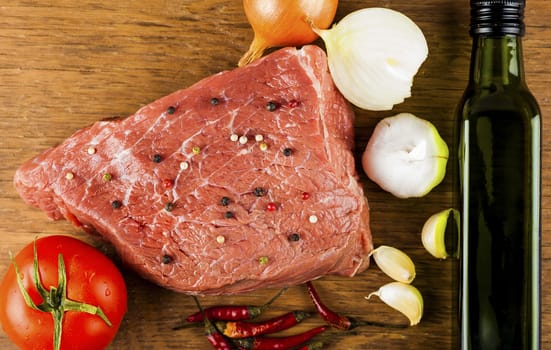beef fillet with spices on a wooden background
