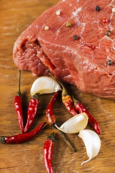 fillet of beef with spices on a wooden background