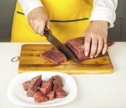 woman cook chopped fresh beef fillet knife