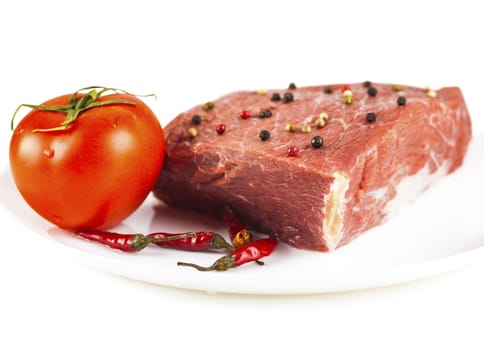 beef filet with spices on a plate, white background