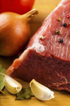 beef filet with spices and vegetables on a wooden board