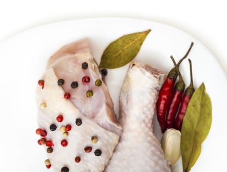 chicken legs on the plate with spices, white background