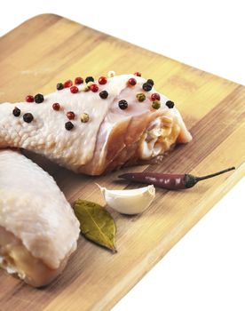 chicken feet on wooden board with spices, white background