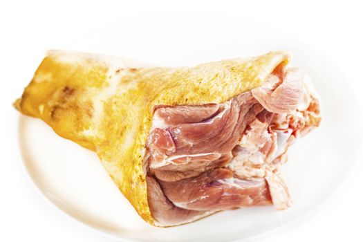 raw pork shank on a plate, white background