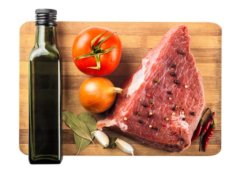 beef filet with spices and vegetables closeup on wooden board, white background