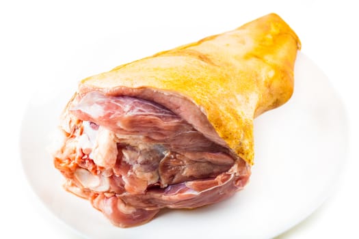 Fresh raw pork shank on a plate, white background