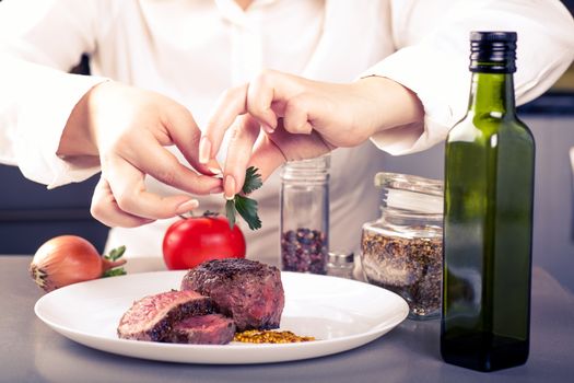 cook completes the dish of delicious cooked medallions