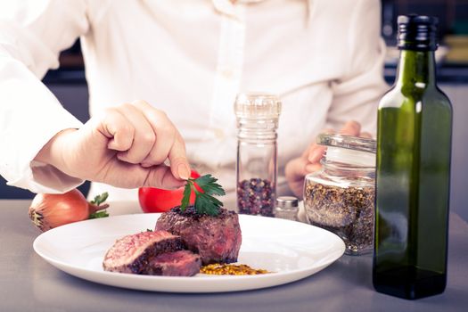 cook completes the dish of medallions, are nearby spices