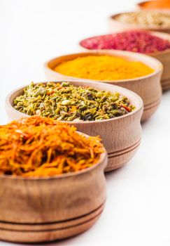 saffron,paprika,sumac,turmeric,green pepper in a wooden bowl on white background