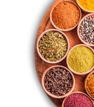 assorted spices in a wooden bowl on white background